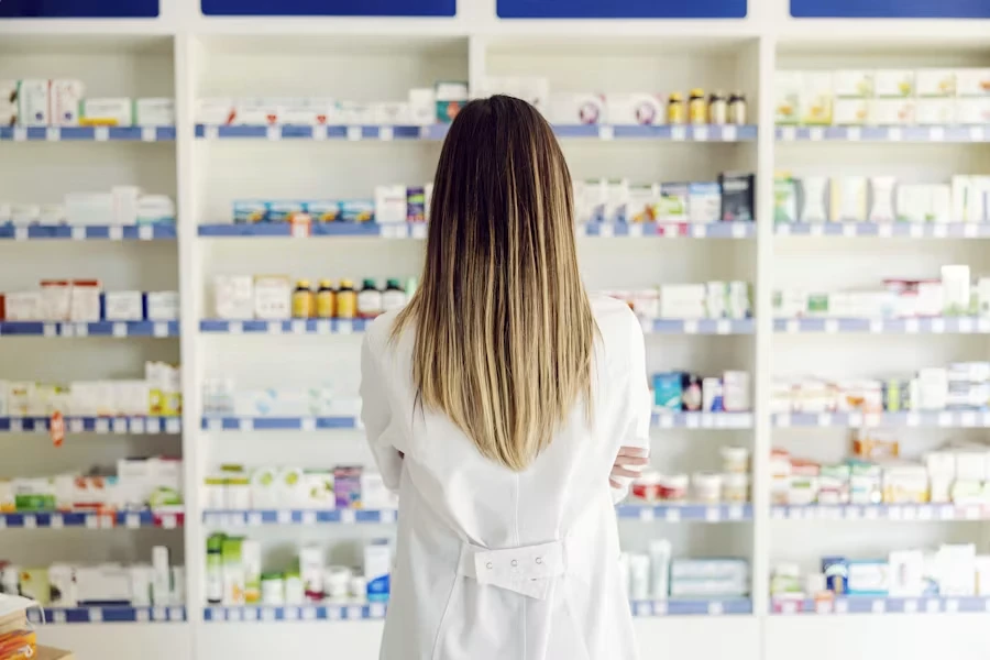 A pharmacist by the medicine shelves in a pharmacy — healthcare in Portugal, the SNS and private clinics